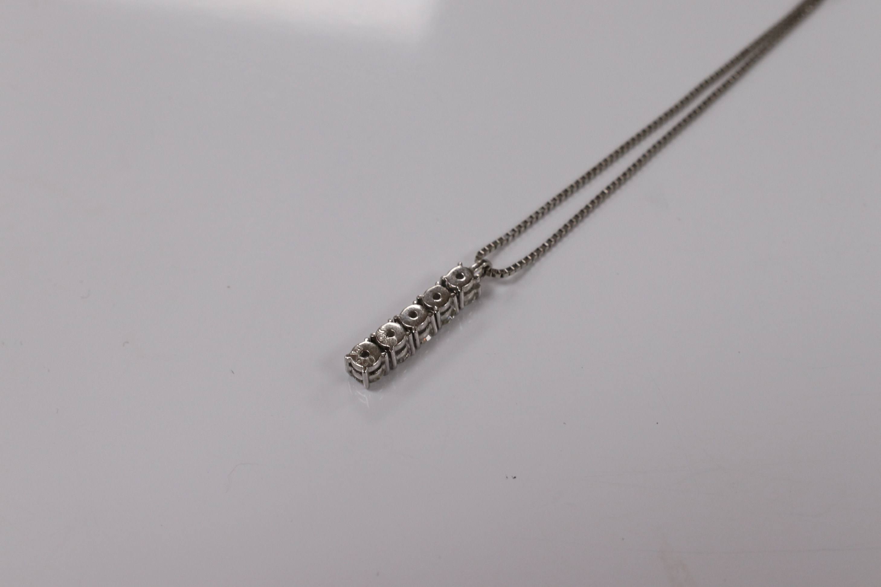 A modern white metal (stamped PT900) and five stone diamond set line pendant, on white metal (stamped pt850), overall 49cm, gross weight 4.9 grams. Condition - fair to good